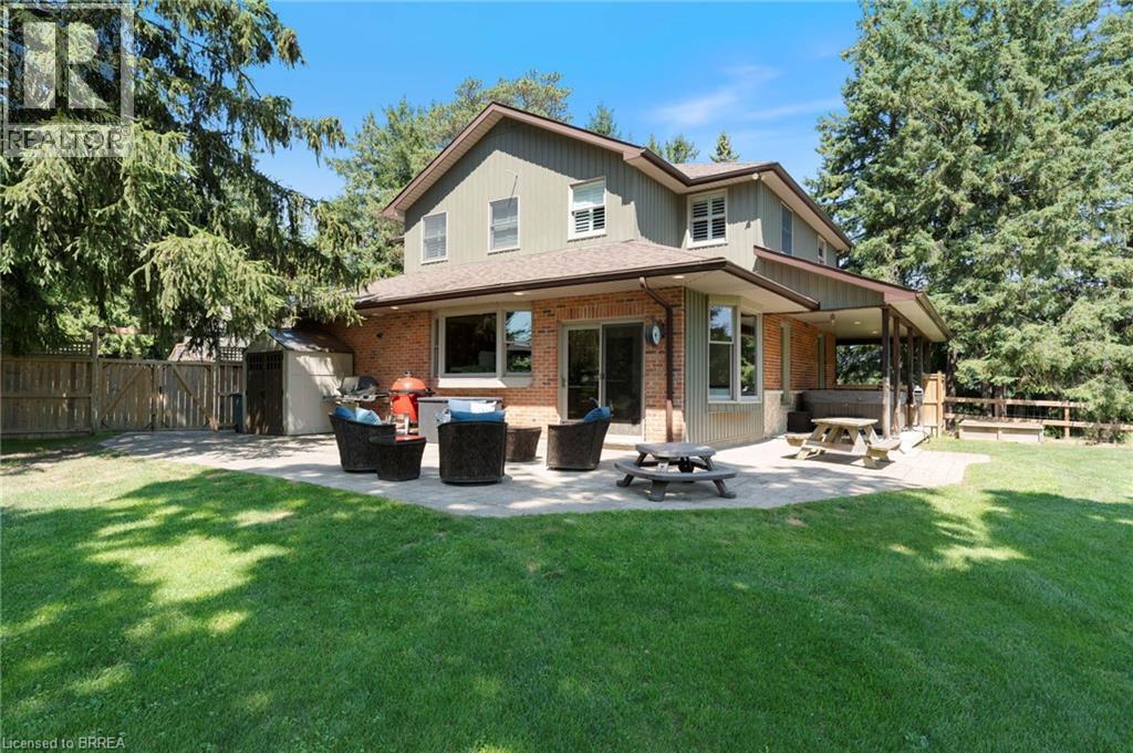 Back of house with a patio area, brick siding, and a gate