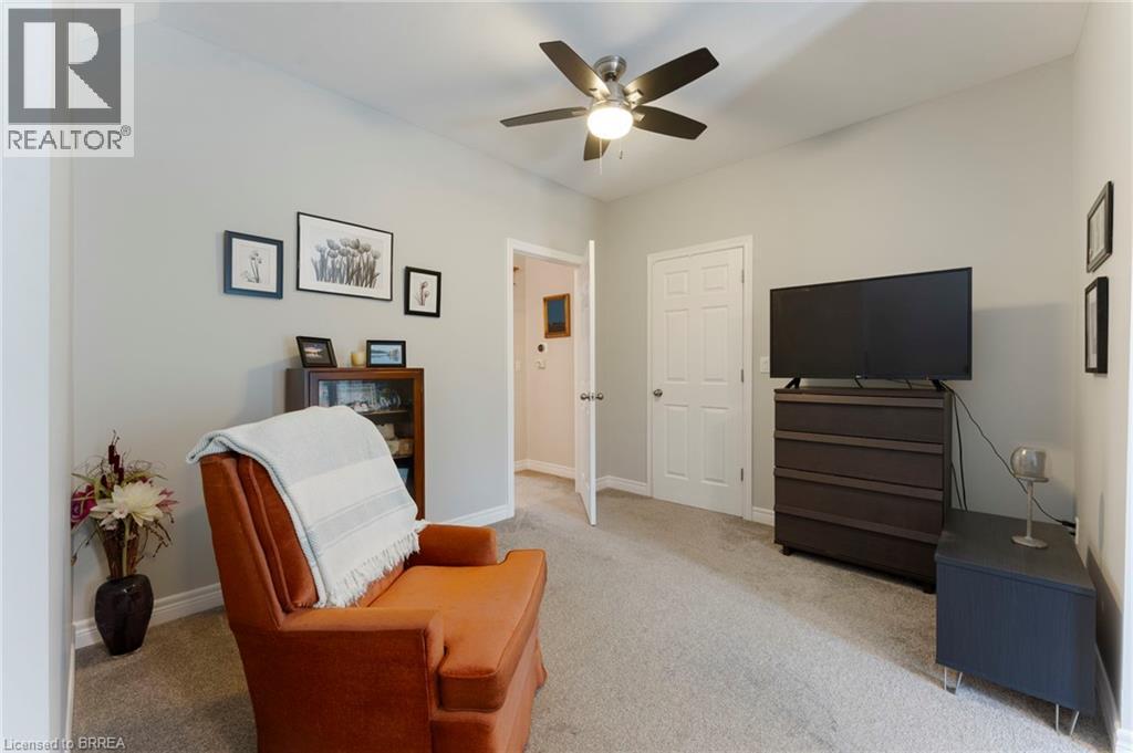 Sitting room with light colored carpet and ceiling fan