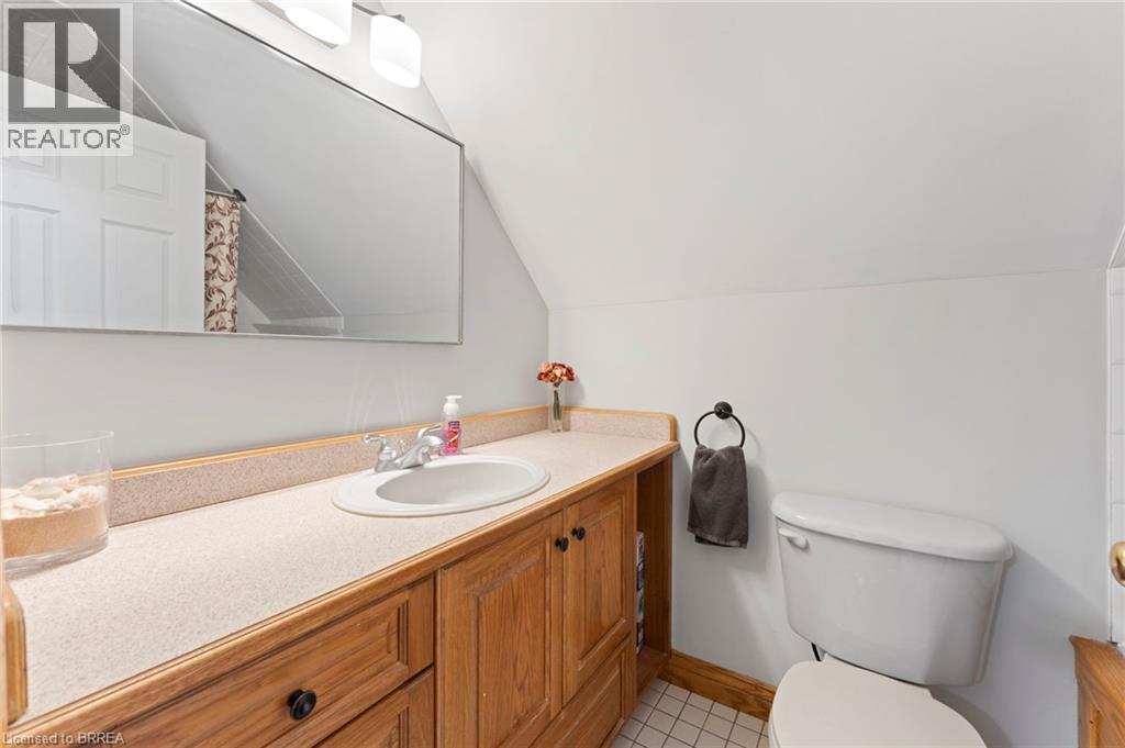Bathroom with vanity, a shower with shower curtain, lofted ceiling, and light tile patterned floors