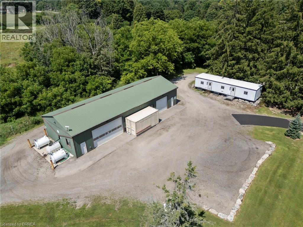 Aerial view of property and surrounding area with a heavily wooded area