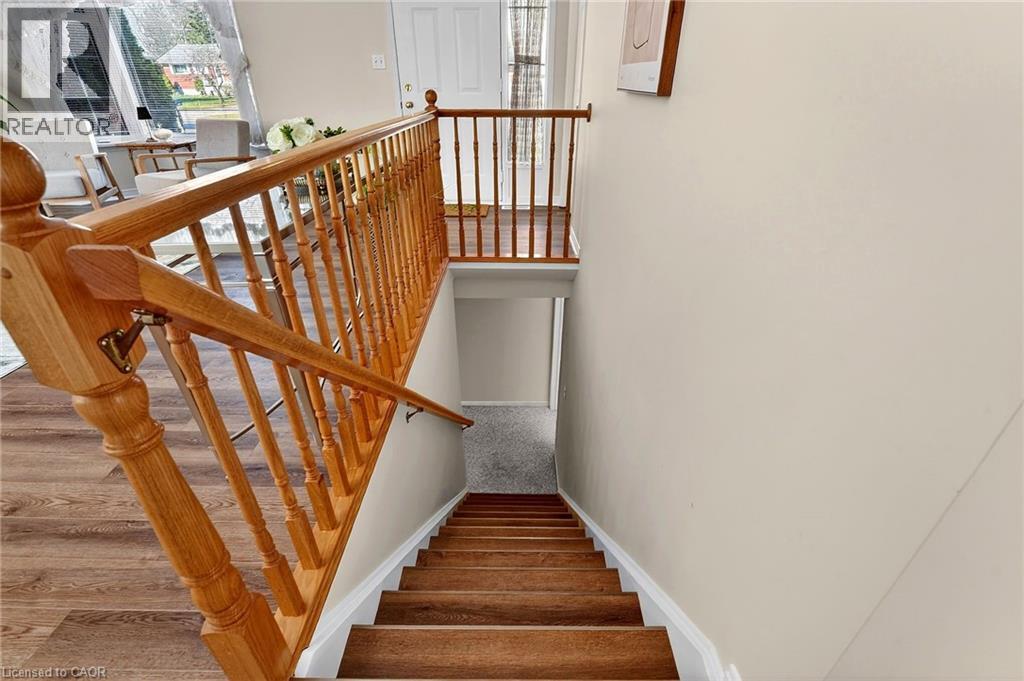 Staircase featuring wood steps and a matching wood banister, with light colored walls