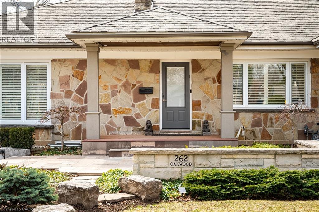 View of exterior entry featuring stone siding and covered porch