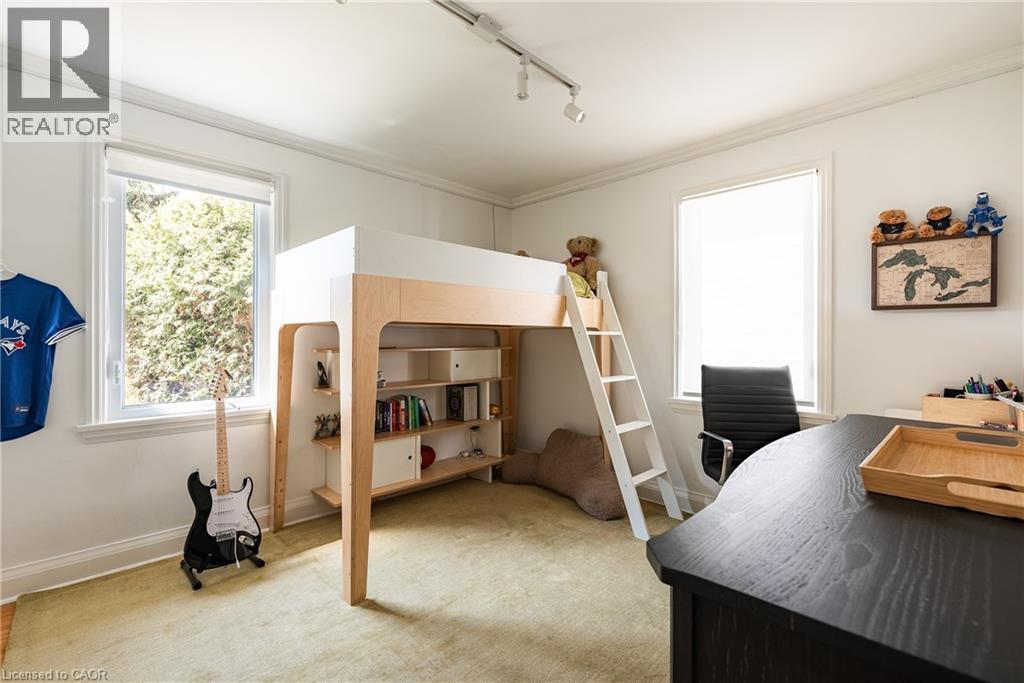 Bedroom featuring rail lighting, light carpet, an office area, and ornamental molding