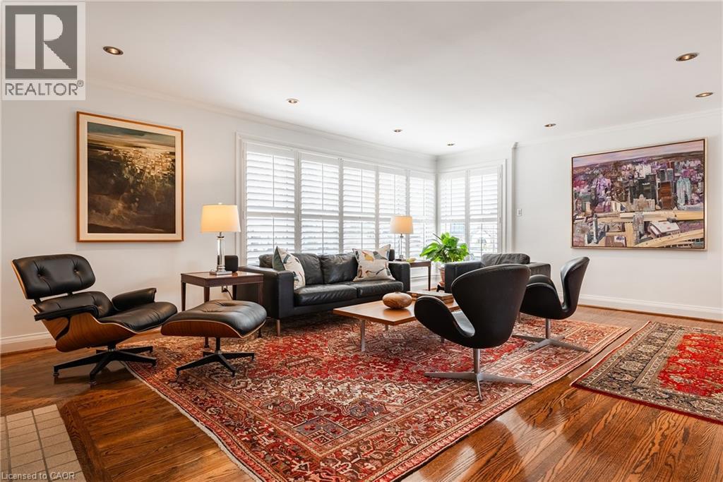 Living area featuring wood finished floors, ornamental molding, and recessed lighting