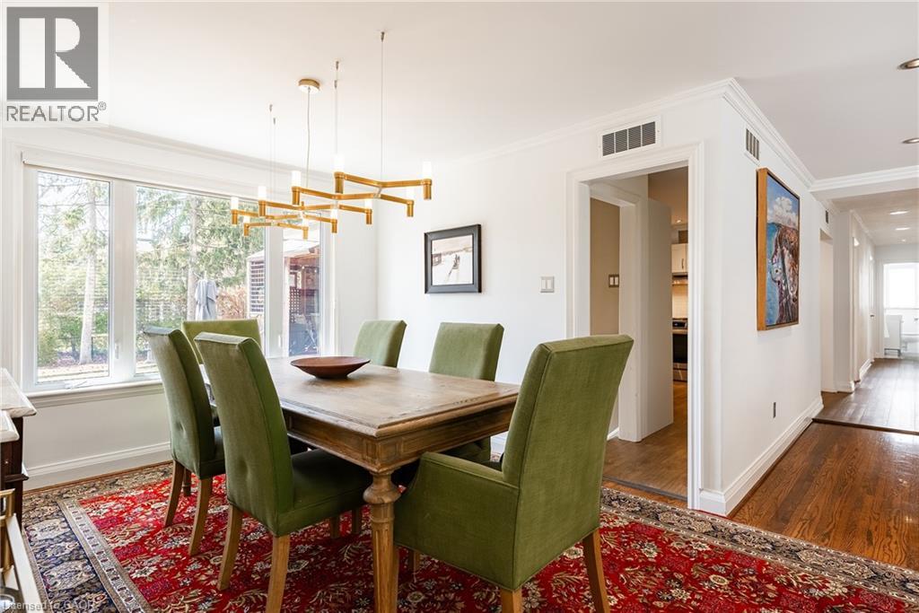 Dining space with hanging lights, crown molding, and dark wood-type flooring