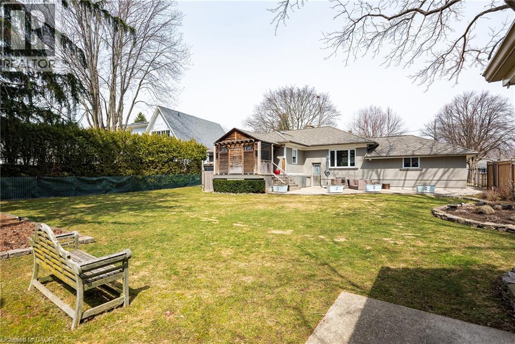 Back of house with a fenced backyard, a wooden deck, and a patio