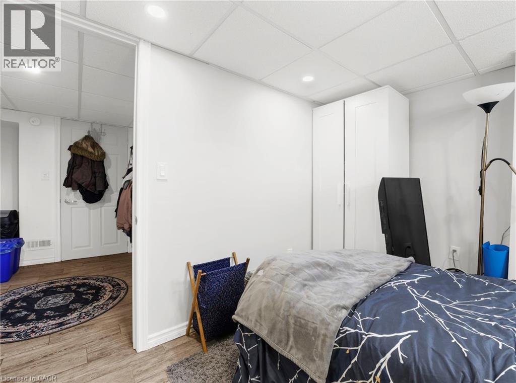 Bedroom with a drop ceiling, light wood-style flooring, and recessed lighting