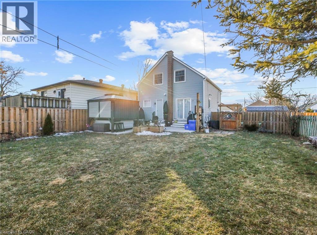 Rear view of house with a patio area, a fenced backyard, entry steps, and a chimney
