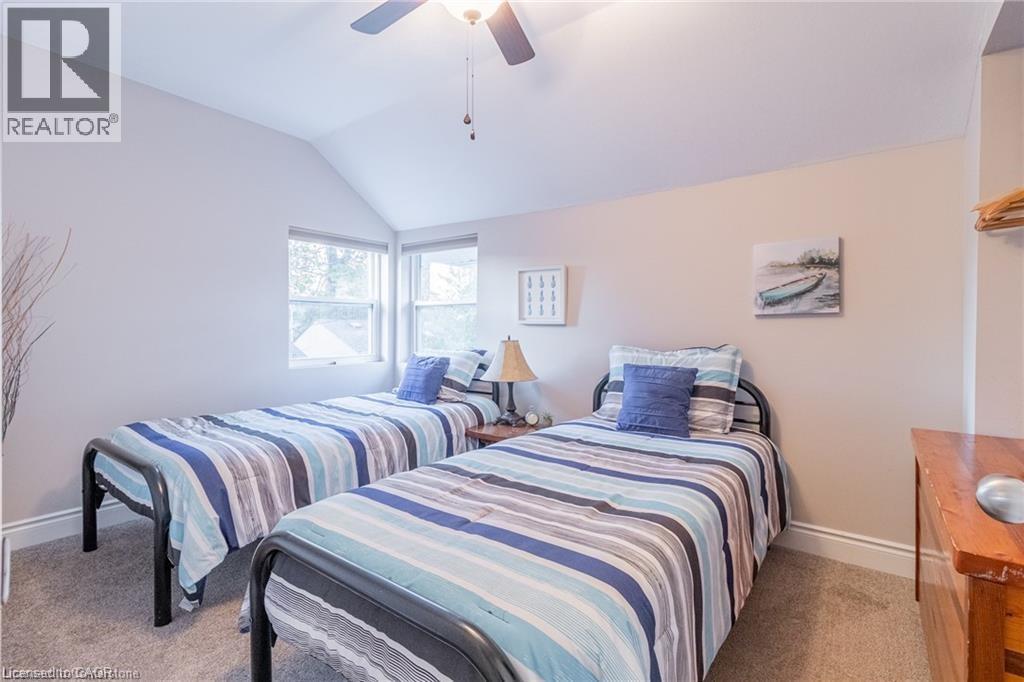 Bedroom featuring ceiling fan, lofted ceiling, and light carpet