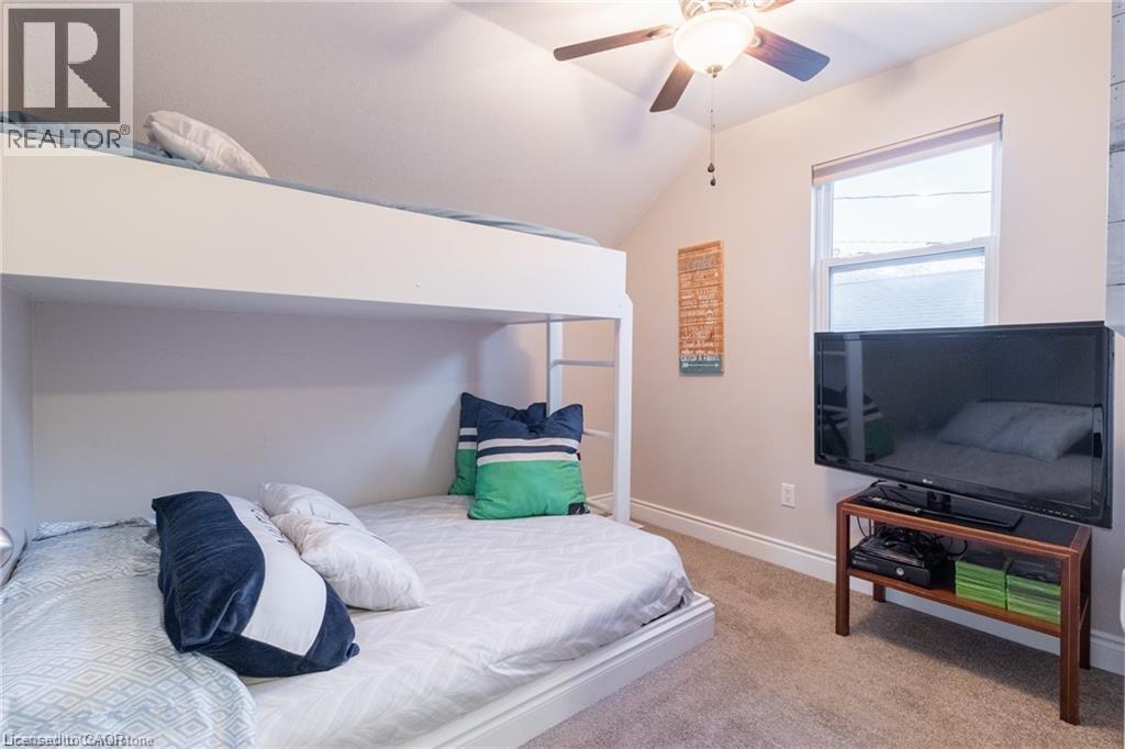 Bedroom featuring light colored carpet, ceiling fan, and lofted ceiling