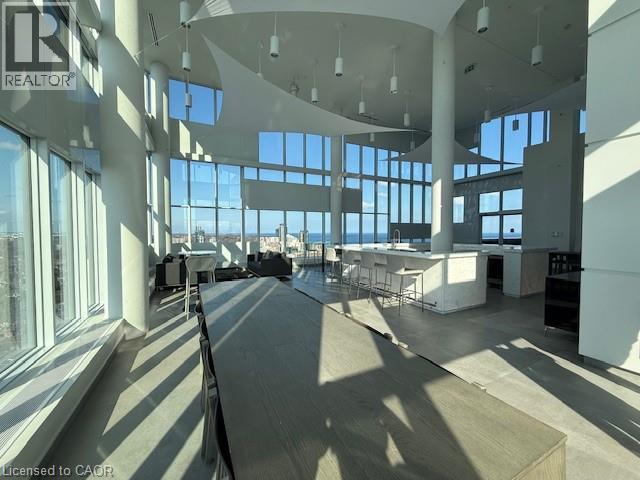 Expansive interior space featuring a high ceiling, large windows with views of the water, and light-colored flooring