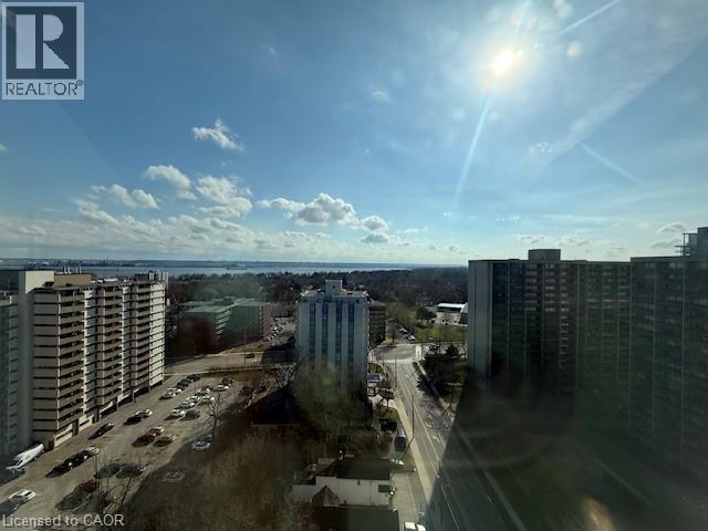 Expansive views of the surrounding urban landscape, including distant water, and a bright, clear sky with scattered clouds