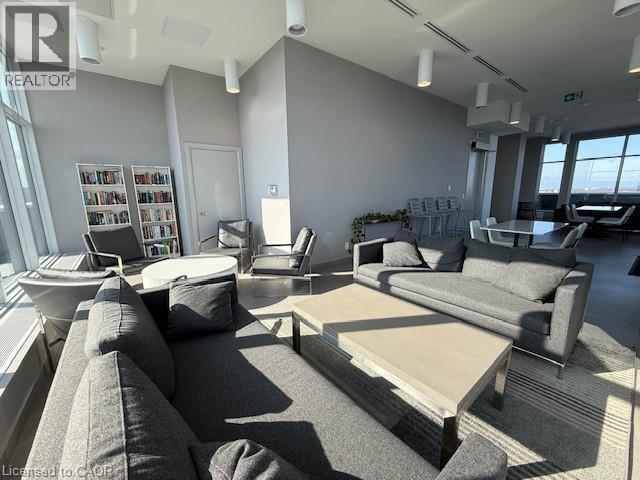 Spacious common area featuring large windows, modern overhead lighting, and comfortable seating arrangements