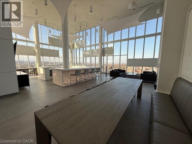 The property features expansive floor-to-ceiling windows, a large bar area with seating, and a spacious communal table