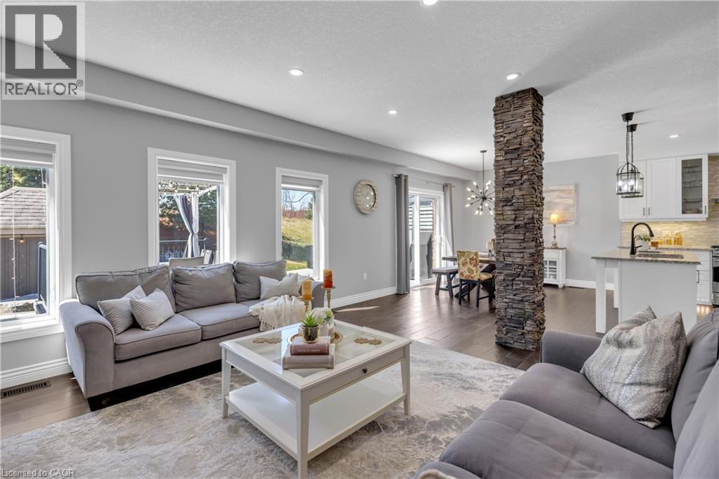 Living area with dark wood-style flooring and a chandelier