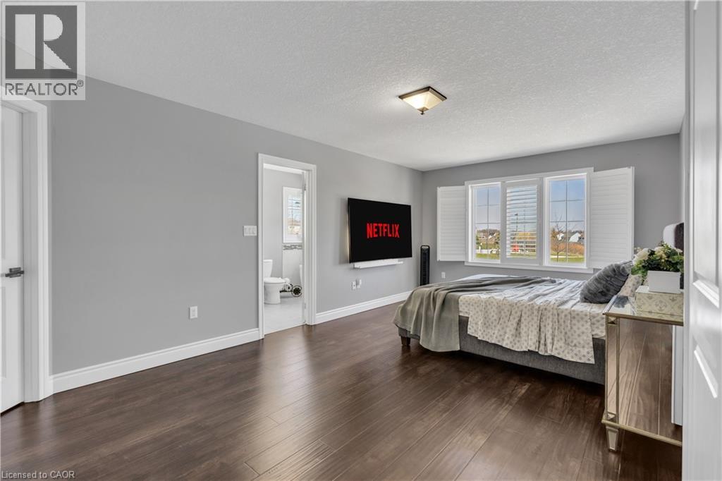 Bedroom with a textured ceiling and dark wood finished floors