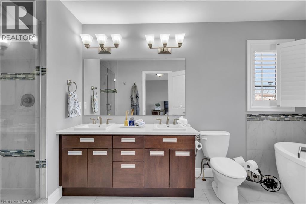 Bathroom featuring double vanity, a shower stall, and a soaking tub