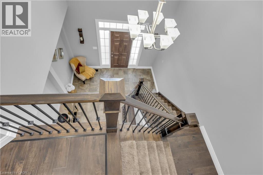 Stairway with hanging lights and wood finished floors