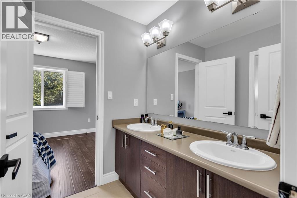 Full bath featuring baseboards and double vanity