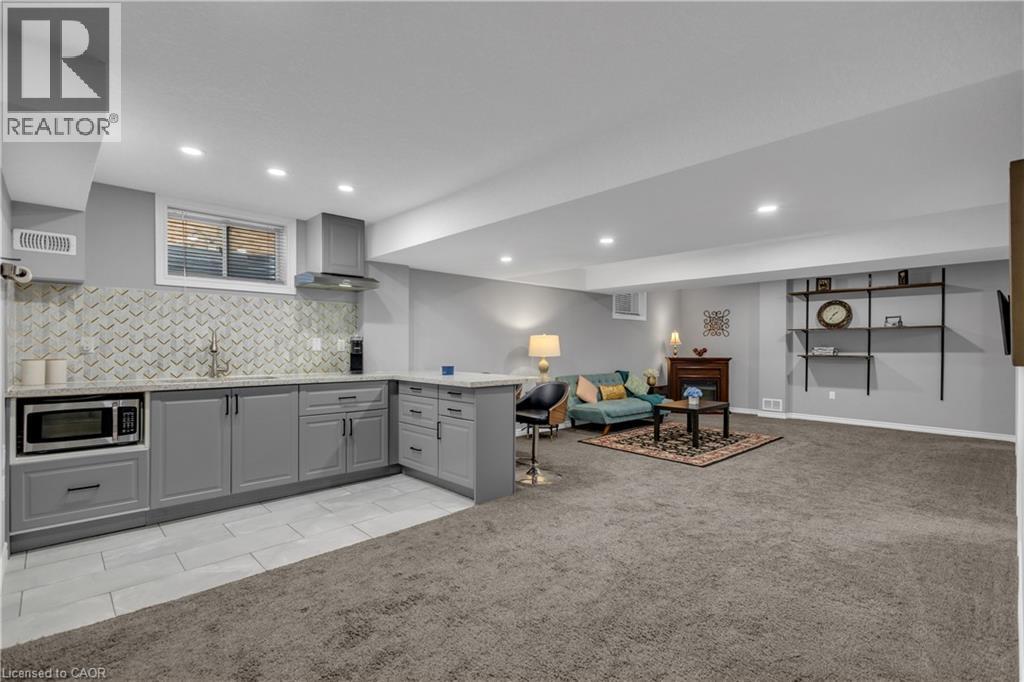 Kitchen featuring gray cabinets, light colored carpet, light tile patterned flooring, and open floor plan