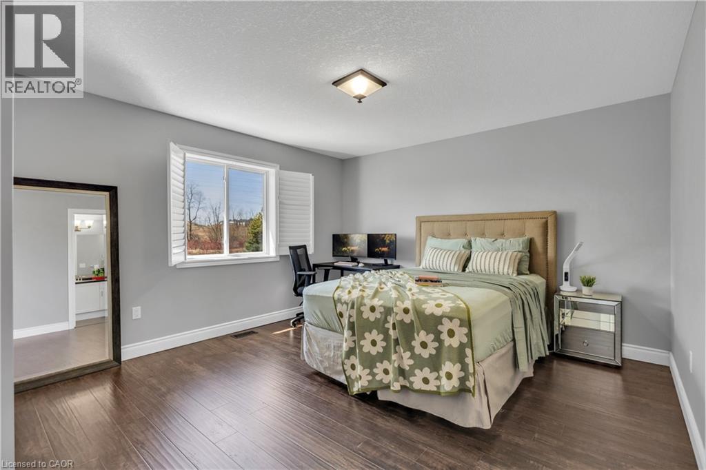 Spacious room featuring dark wood flooring, light grey walls, and a large window with white shutters