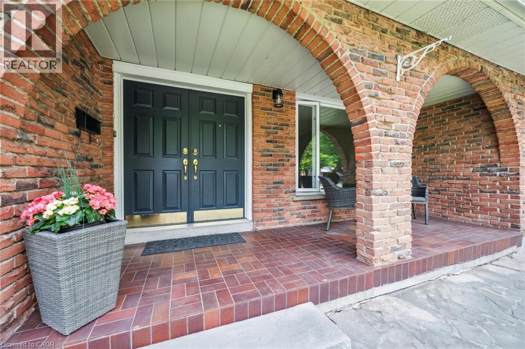View of exterior entry featuring a porch and brick siding