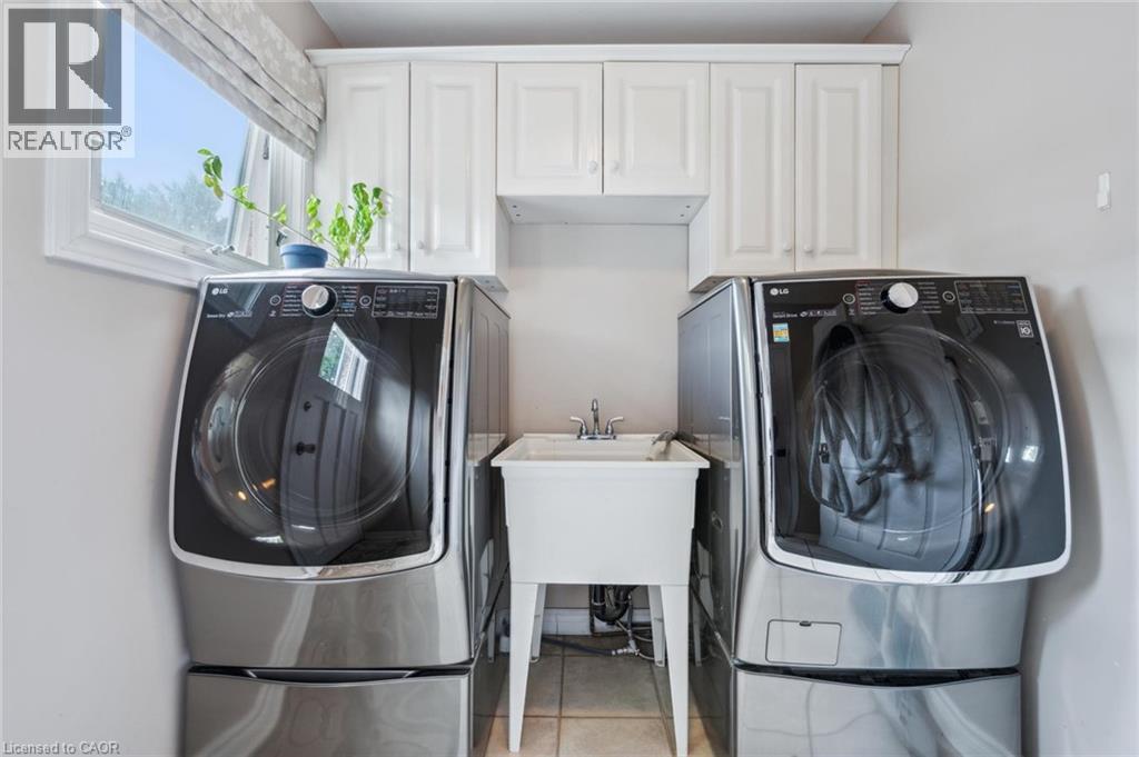 Laundry room with washing machine and dryer, cabinet space, and light tile patterned floors