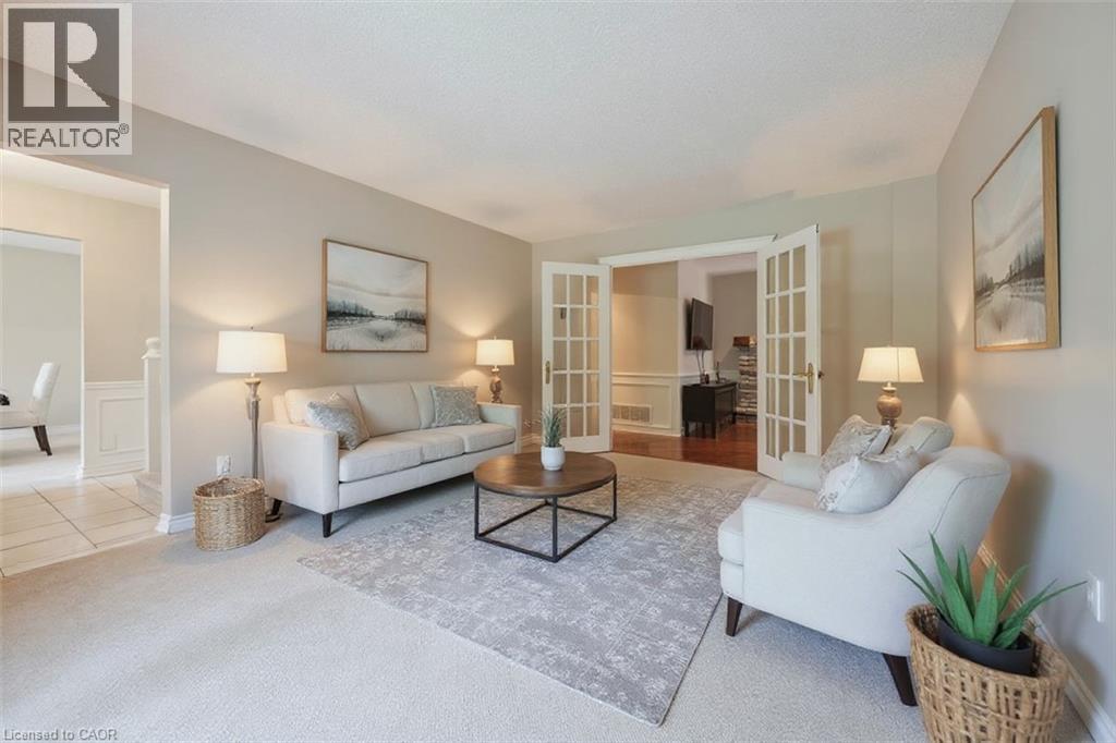Carpeted living room with french doors and a wainscoted wall