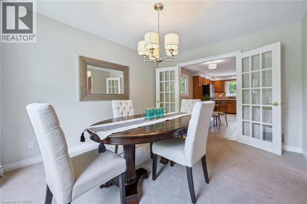 Dining room featuring light carpet, hanging lights, and french doors