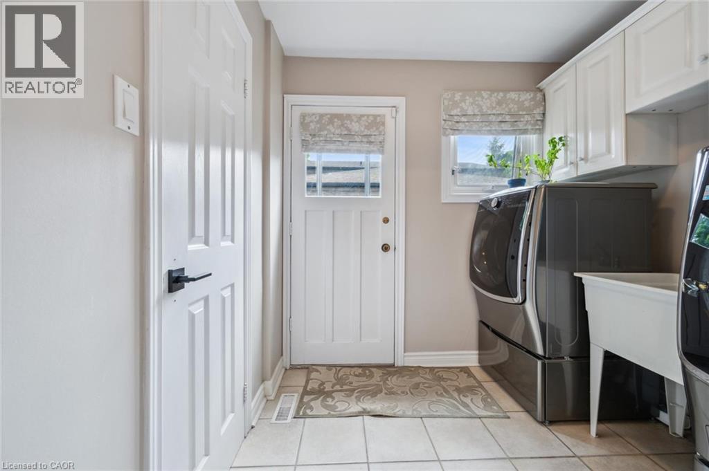 Laundry area featuring light tile patterned floors, cabinet space, and separate washer and dryer