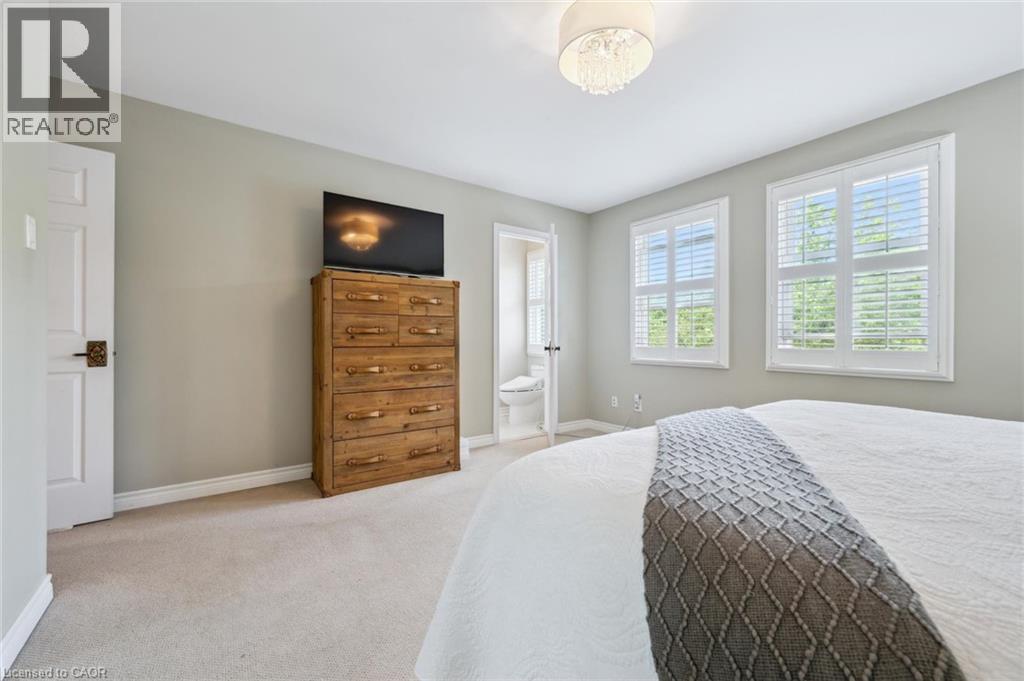 Bedroom with light carpet and ensuite bath