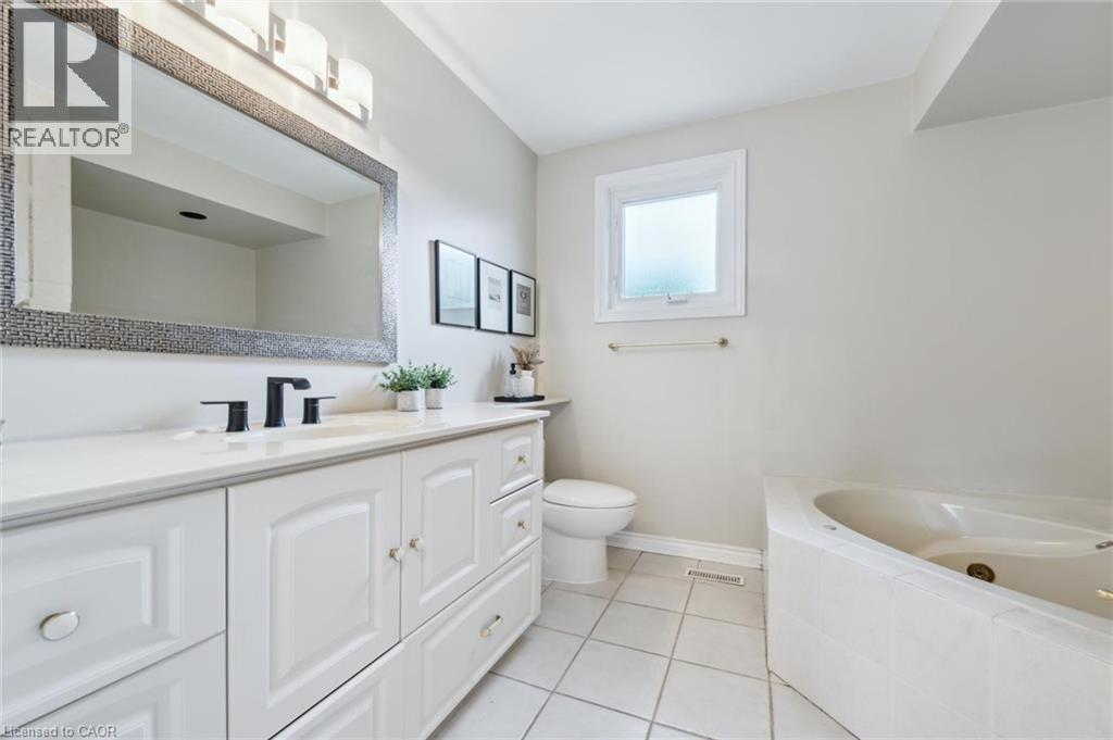 Bathroom with vanity, a whirlpool tub, and light tile patterned flooring
