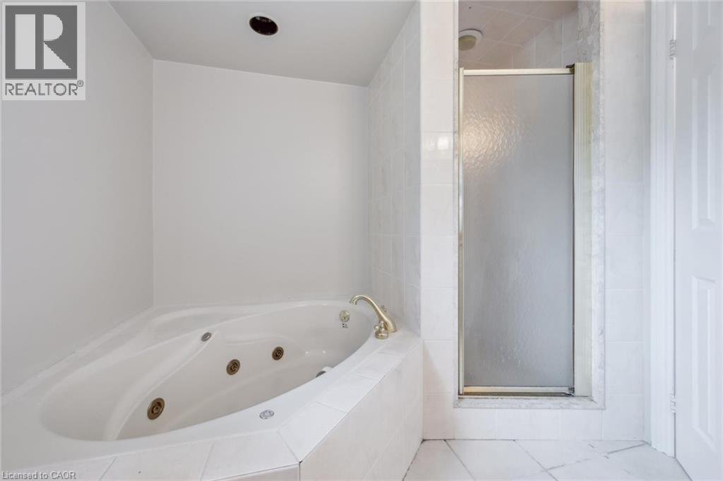 Full bathroom featuring a stall shower, a tub with jets, and tile patterned floors
