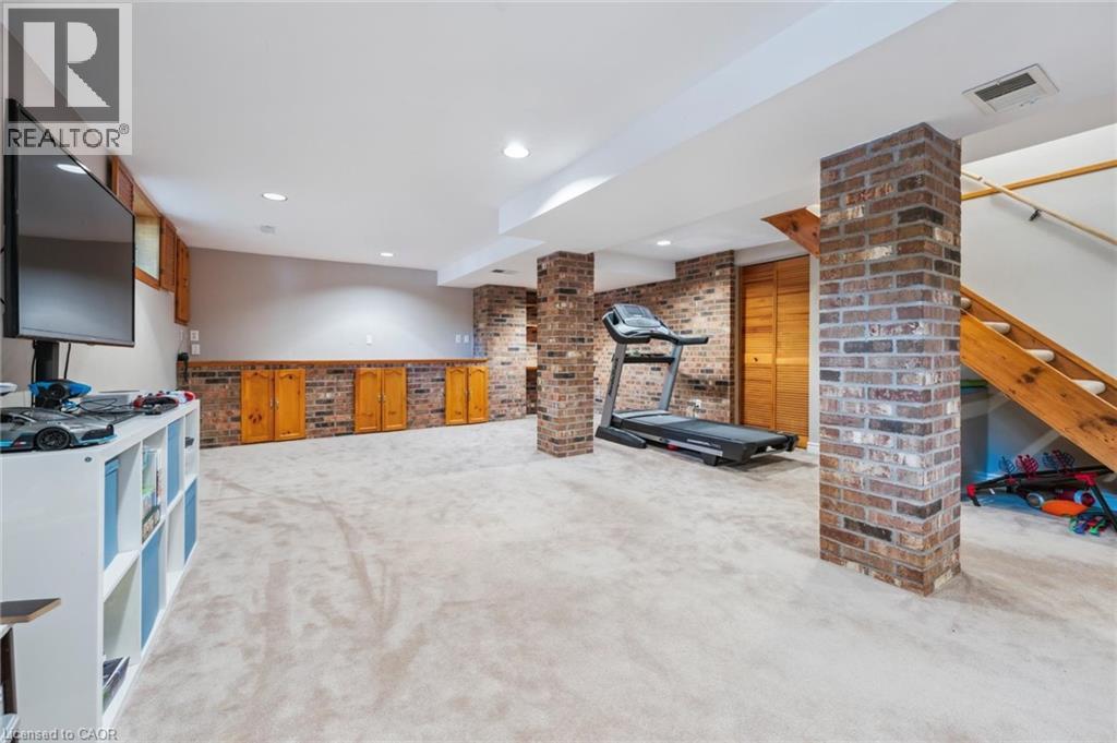 Workout area with light colored carpet, brick wall, and recessed lighting