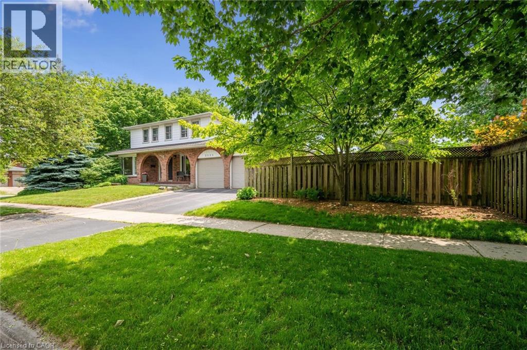 View of front of property featuring a porch, a garage, asphalt driveway, and brick siding