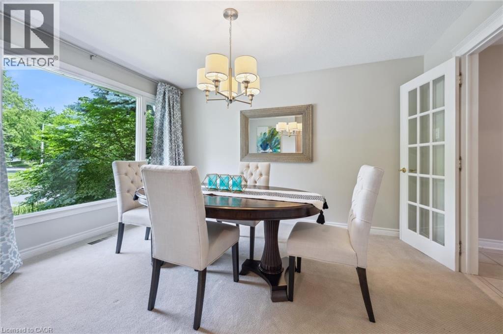 Dining space featuring suspended lighting and light colored carpet