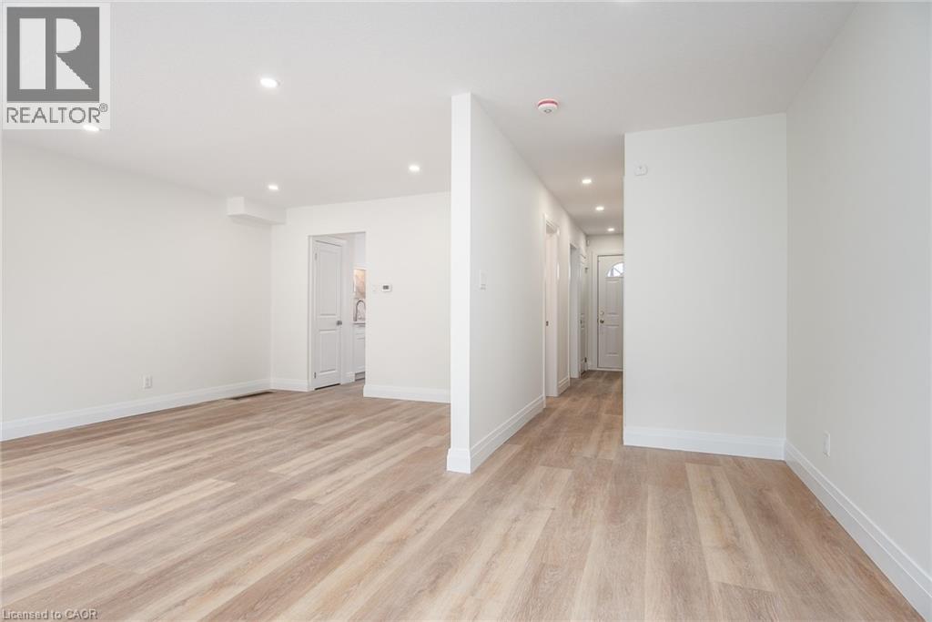 Empty room with light wood-style floors and recessed lighting