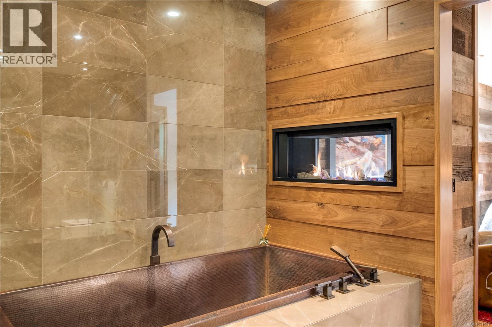 Imported, custom, hand hammered, copper bathtub and double sided fireplace creates a healing abode.