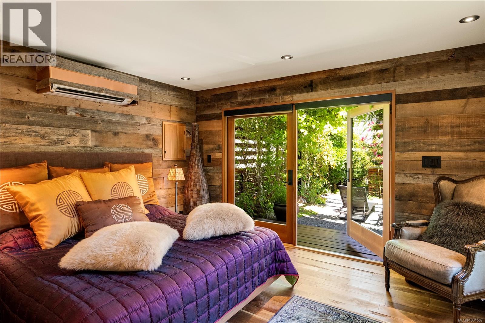 Walnut floors and oversized French doors lead to a deck and pergola.