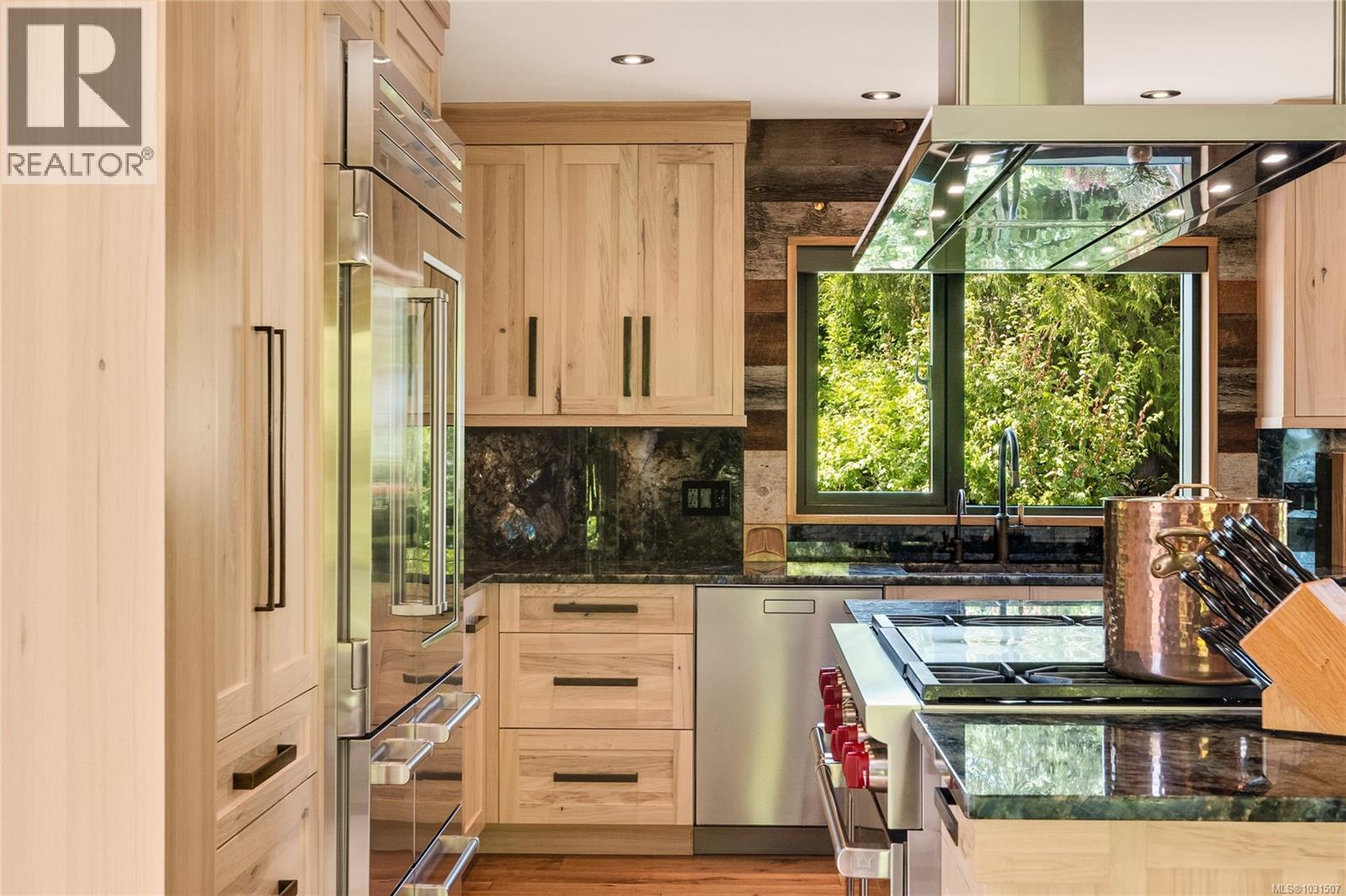 State of the art appliances include: 48'' Wolf Dual Fuel Range (red knobs) with infrared charbroiler and double griddle; 48'' PRO Sub-Zero Refrigerator/Freezer with glass door and a FALMEC Lumen Hood.
