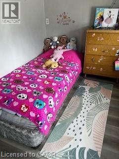 This room features a bed with a vibrant blanket, a patterned rug, and a wooden dresser