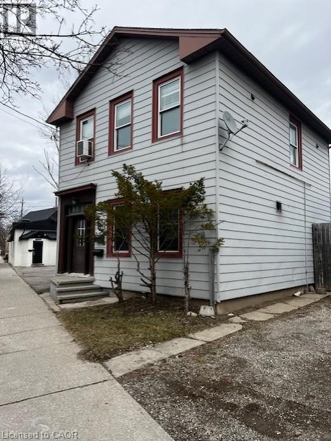 The property features light-colored siding, dark trim around the windows, and a multi-level entrance