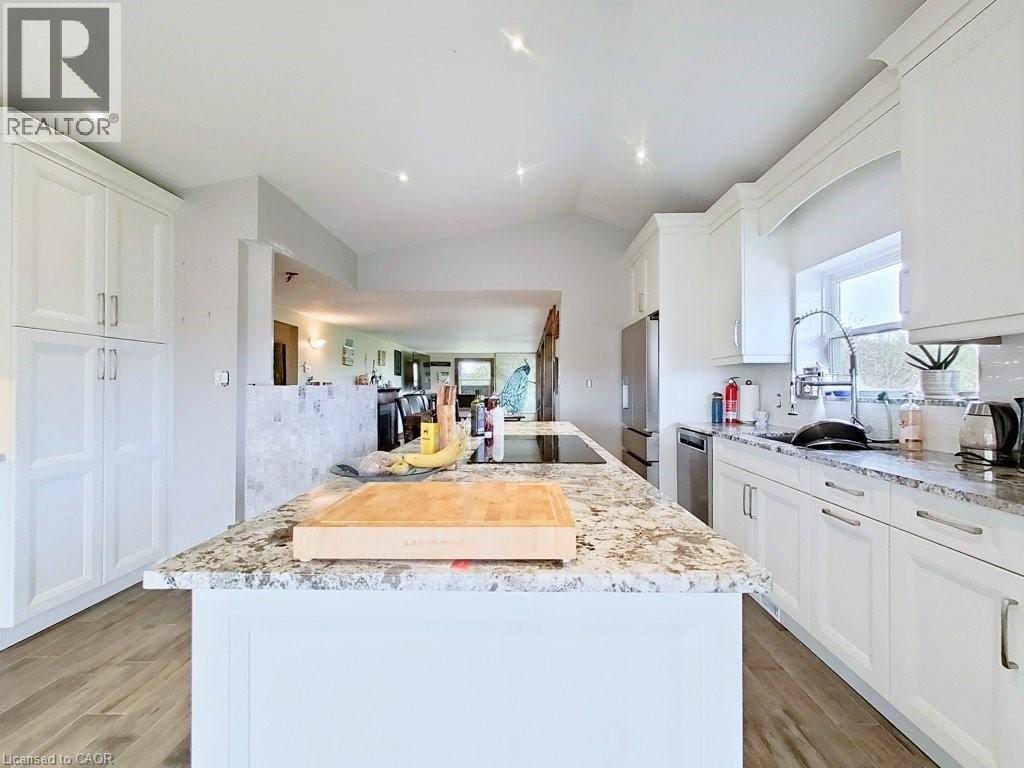 The kitchen features white cabinetry, granite countertops, and stainless steel appliances
