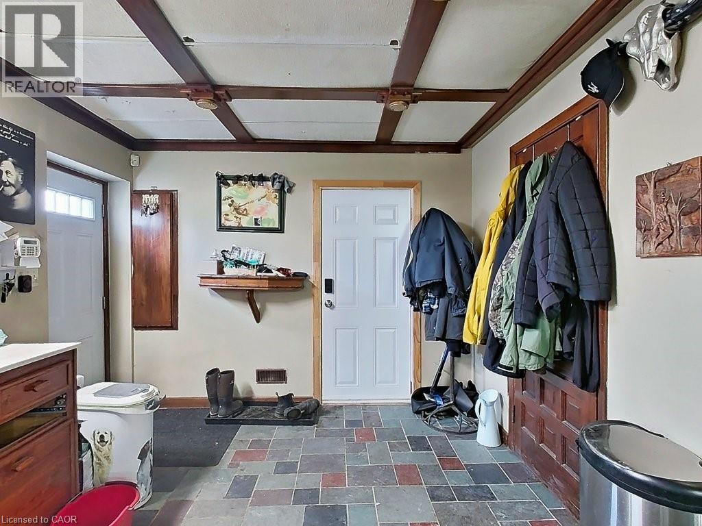 Entryway with coffered ceilings, slate tile flooring, and two white doors