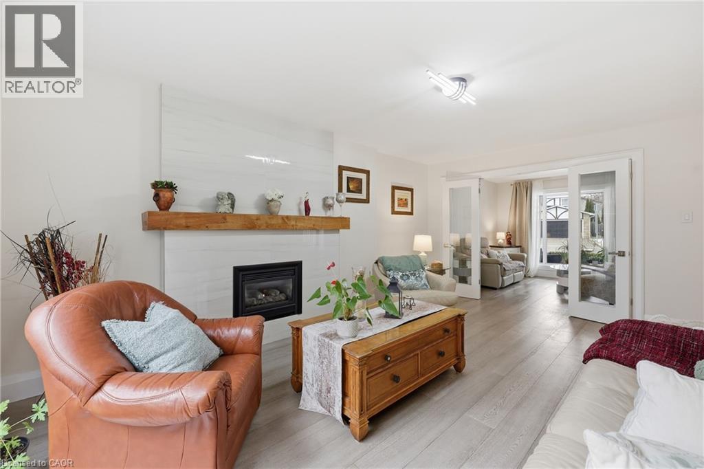Living area with light wood-style floors and a glass covered fireplace