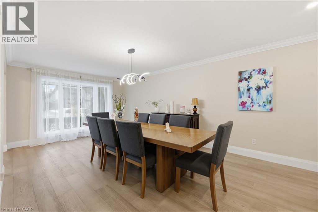 Dining space with ornamental molding, light wood-type flooring, and hanging lights