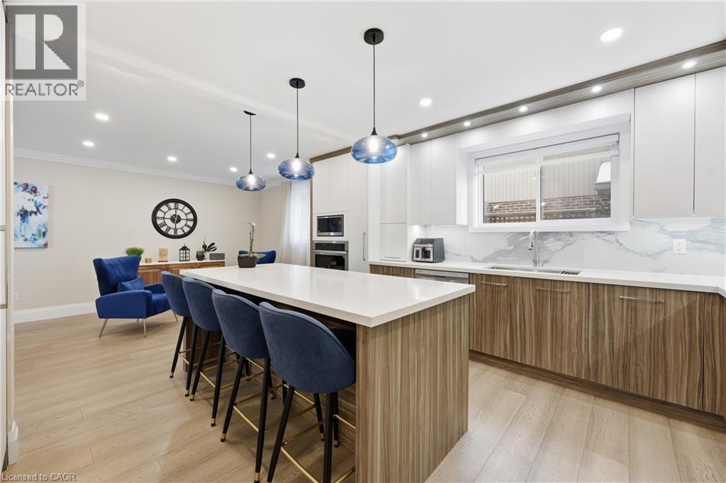 Dual tone kitchen featuring dual tone cabinetry, backsplash, modern cabinets, a kitchen island, and a kitchen breakfast bar