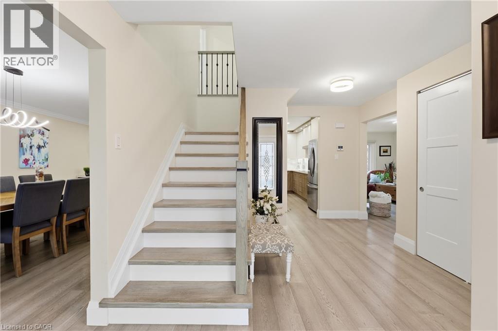 Stairway with wood finished floors and a chandelier