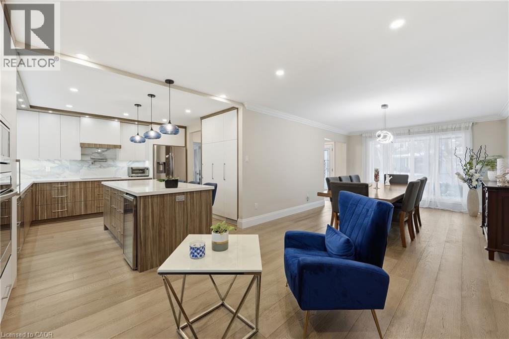 Living area with crown molding, light wood-style floors, wine cooler, and recessed lighting