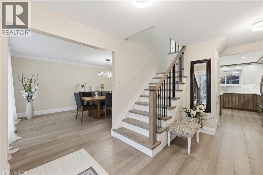 Stairway featuring wood finished floors and a chandelier